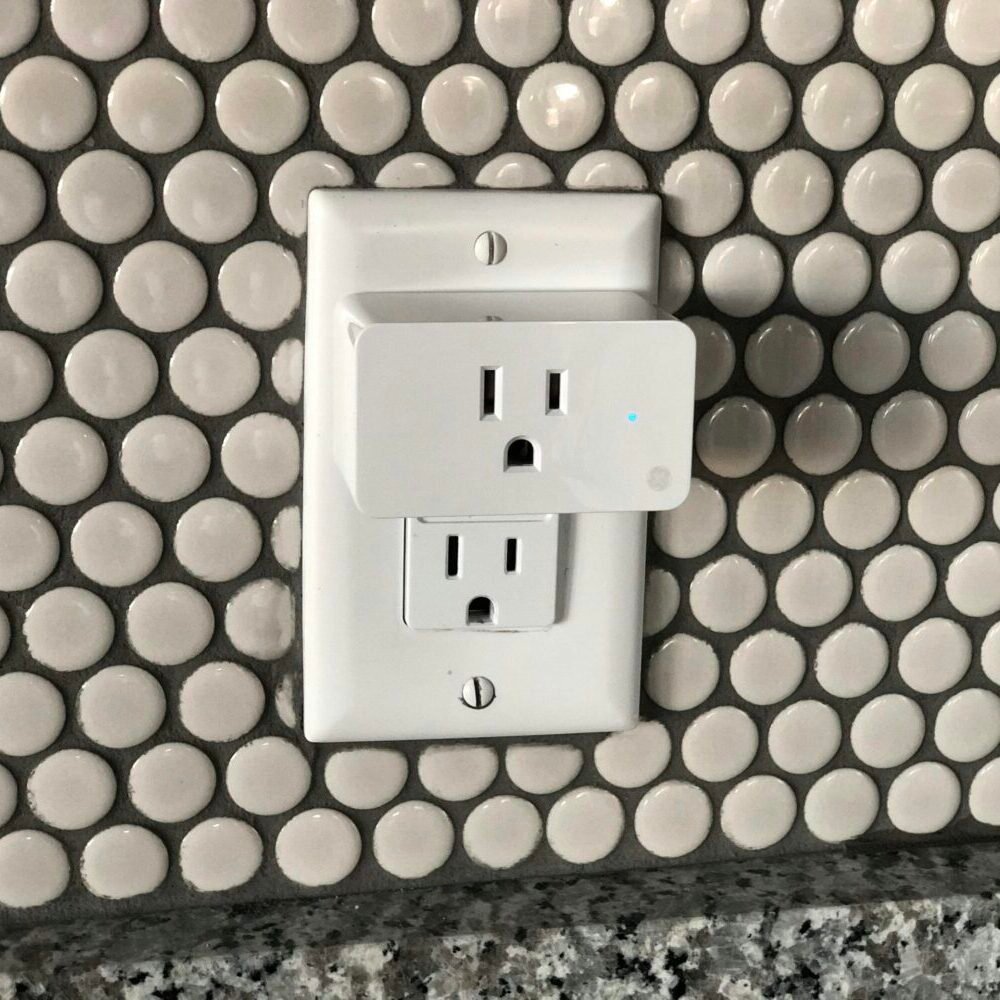 Close-up of a smart plug on a tiled wall showcasing contemporary interior design style.
